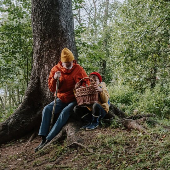 Mann und Kind sitzen im Wald.