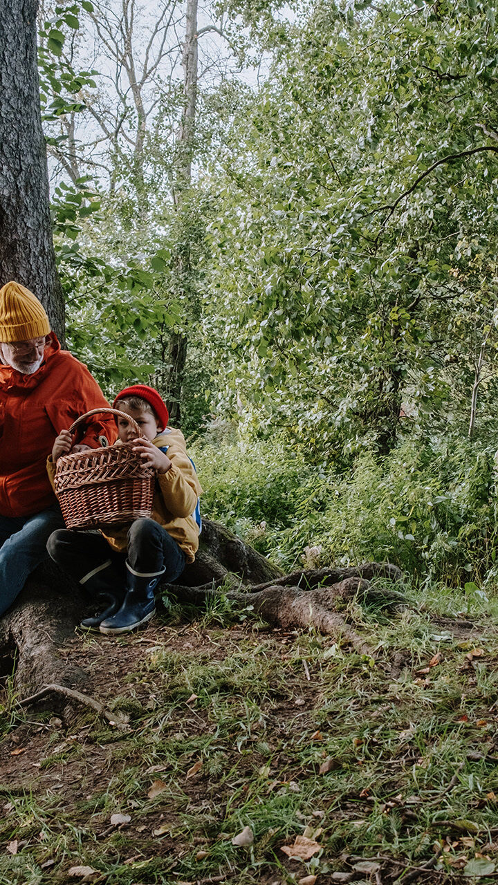 Mann und Kind sitzen im Wald.